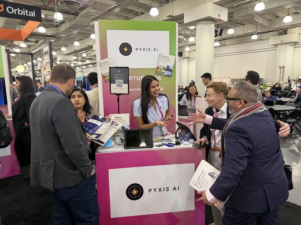 Visitors talking with the Pyxis AI team at the booth