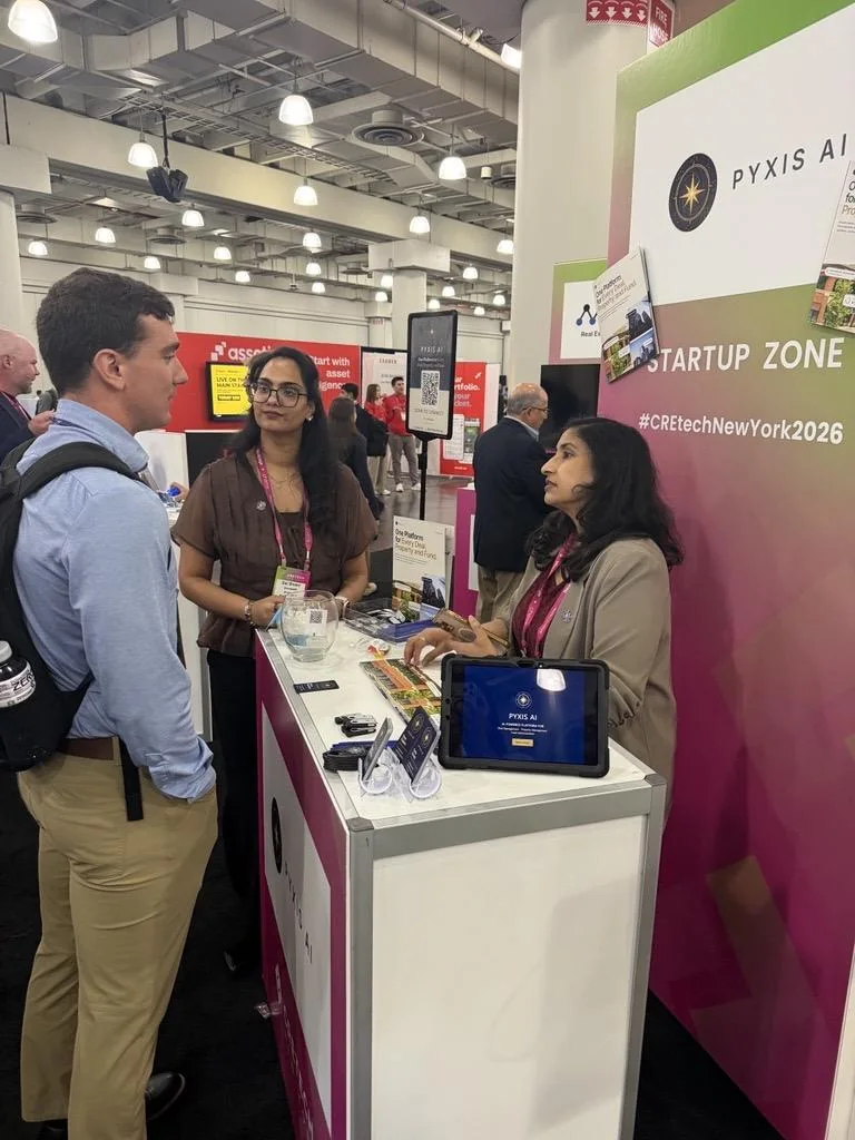 Pyxis AI team talking with a visitor at the booth