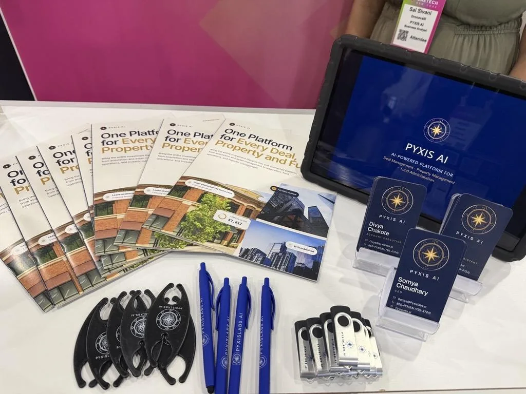 Pyxis AI booklets, business cards, pens and USB drives on the booth counter