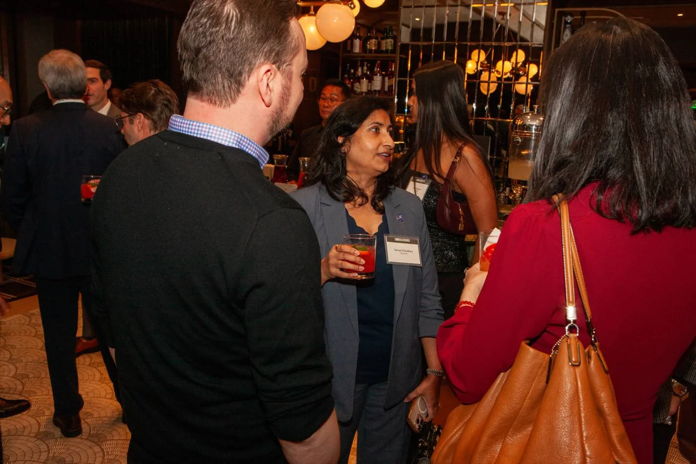 Somya Chaudhary talking with guests at the bar